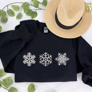 a black sweatshirt with white snowflakes on it