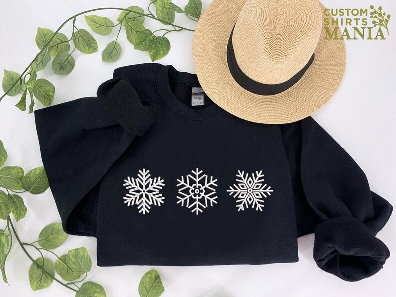 a black sweatshirt with white snowflakes on it
