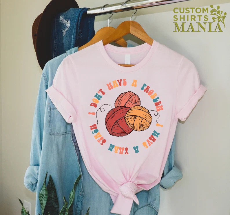May include: Pink t-shirt with a graphic of yarn balls and the text "I don't have a problem I have a yarn stash".