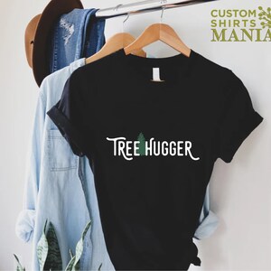 May include: Black t-shirt with a green tree graphic and the text "Tree Hugger" in white.