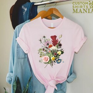a pink t - shirt with a bouquet of flowers on it