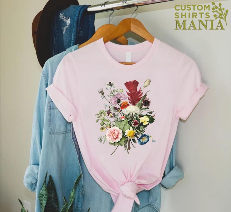 a pink t - shirt with a bouquet of flowers on it