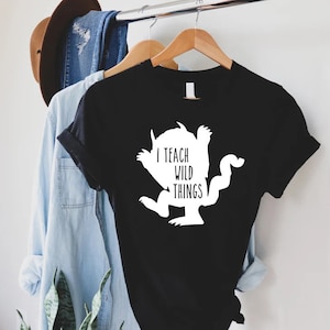 May include: Black t-shirt with a white silhouette of a monster and the text "I teach wild things".