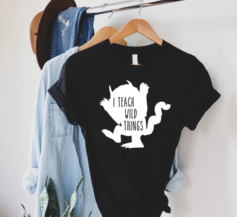 May include: Black t-shirt with a white silhouette of a monster and the text "I teach wild things".