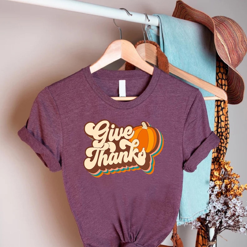 a purple shirt that says give thanks on it