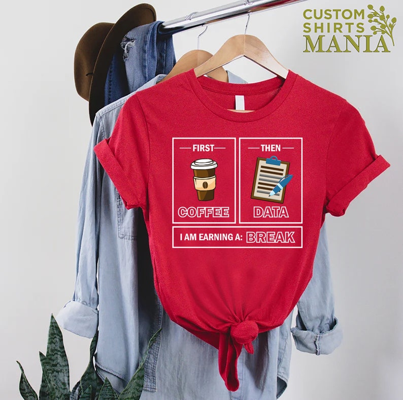 May include: Red t-shirt with a graphic of a coffee cup and a clipboard with a pen. The text reads "First - Coffee, Then - Data, I am earning a: Break".