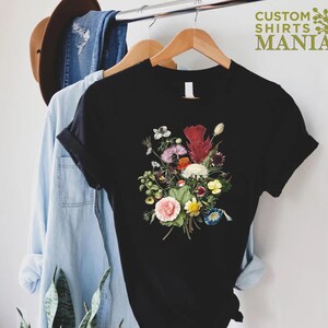 a t - shirt hanging on a rack next to a pair of jeans