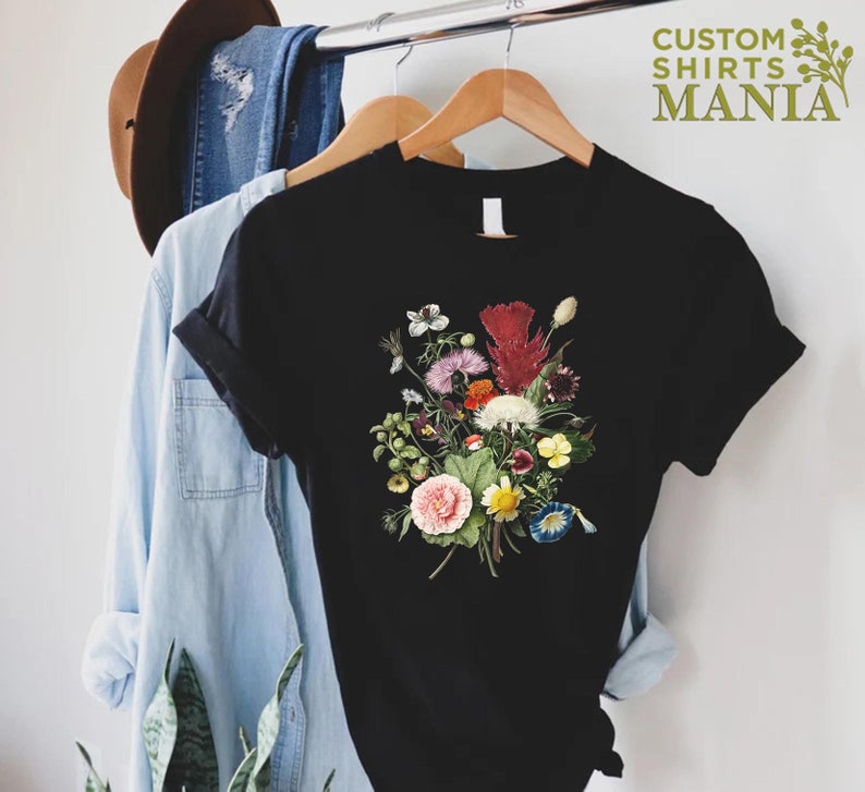 a t - shirt hanging on a rack next to a pair of jeans