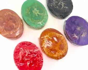 May include: Six oval-shaped bath soap bars in various colors, including orange, green, red, purple, and brown. The soaps are wrapped in clear plastic and have a textured surface.