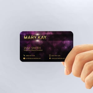 a person holding up a business card with hearts on it