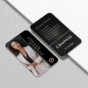 May include: Two business cards with rounded corners. One card features a photo of a woman in a blazer, with the name "Melanie Brooks, Realtor" and a gold accent. The other card is black with white text and the Compass logo.