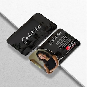 May include: Two black business cards with rounded corners. One card features the name "Cecilia Walker, Realtor" in white script. The other card includes a photo of a woman, contact information, and the Realty World logo.