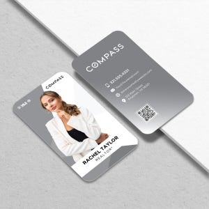 May include: Two gray business cards with rounded corners. One card features a photo of a woman in a white blazer, the text "RACHEL TAYLOR REALTOR", and the Compass logo. The other card displays contact information and the Compass logo.