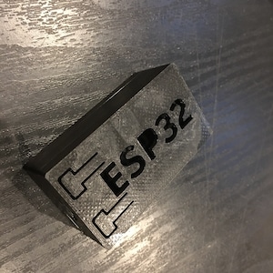 May include: A black 3D printed box with the text "ESP32" printed on the top.