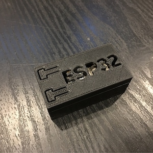 May include: A black 3D printed box with the text "ESP32" printed on the top.