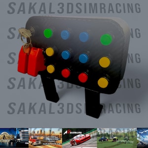 May include: A black control panel with colorful buttons and a key. The panel has green, blue, yellow, and red buttons. The text "SAKAL3DSIMRACING" is visible. The panel is designed for sim racing.