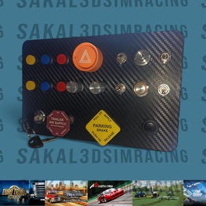 May include: A black control panel with a carbon fiber texture, featuring various buttons, switches, and a large orange button. Includes labels for trailer air supply and parking brake. A set of keys is also visible.