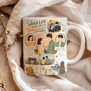 Może przedstawiać: Biały ceramiczny kubek z kolorowymi ilustracjami pary, mandarynek, łodzi i kamiennej figury. Tekst zawiera napis When Life Gives You Tangerines, Ae-sun, Gwan-sik oraz różne frazy. Projekt przedstawia wiele scen z udziałem dwojga ludzi.