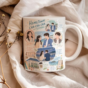 May include: A white ceramic mug featuring colourful illustrations and text from the show Hometown Cha-Cha-Cha. The design includes character portraits, a seaside town scene, a coffee cup, and various handwritten phrases printed on the surface.