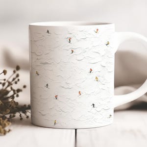 May include: White ceramic mug with a repeating pattern of skiers on a snowy mountain. The skiers are in colourful outfits, contrasting with the white background. The mug has a curved handle, perfect for hot beverages.