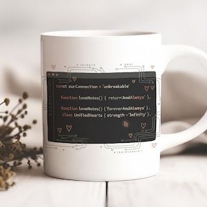 Może przedstawiać: Biały ceramiczny kubek z czarnym prostokątem zawierającym fragmenty kodu i tekstem "const ourConnection = 'unbreakable'". Kubek ma uchwyt i jest ozdobiony małymi sercami i wzorami obwodów.