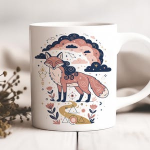 Puede incluir: Taza de cerámica blanca con una ilustración estilizada de un zorro con temática celestial. El zorro está representado en tonos rosa y marrón, con una nube azul oscuro y un diseño de constelación. Elementos florales y geométricos.