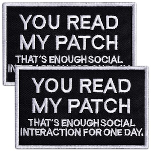 May include: Two rectangular black embroidered patches with white stitched borders. The text reads: YOU READ MY PATCH THAT'S ENOUGH SOCIAL INTERACTION FOR ONE DAY. The lettering is in a bold, white, sans-serif font against the black fabric background.