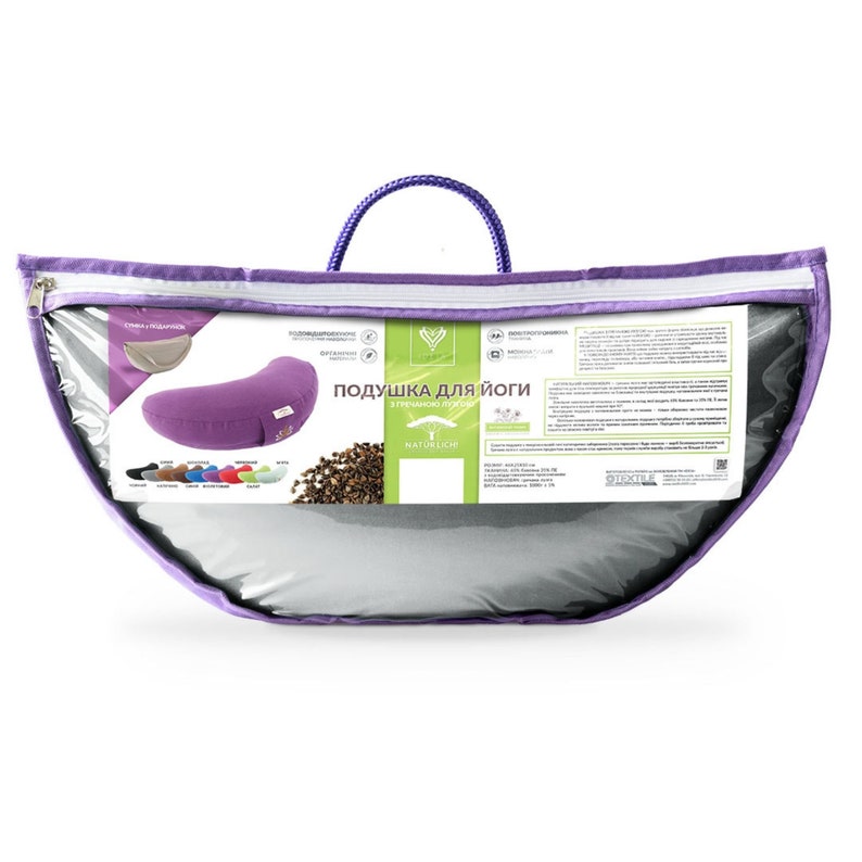 May include: A purple yoga pillow in a clear plastic bag with a purple handle. The pillow is crescent-shaped and has a small tag. The bag also contains a product information card and a color chart of available pillows.