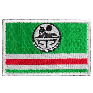 May include: Embroidered patch depicting the flag of the Chechen Republic. The design features a green field, a white stripe, a red stripe, and a circular emblem with a wolf and sun. The patch has a white border.