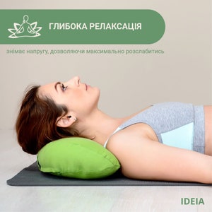 May include: A woman lying on a gray mat with a green pillow supporting her head. The image has text in the upper left corner that reads "Глибока релаксація" and below it, text that reads "знімає напругу, дозволяючи максимально розслабитись". The IDEIA logo is in the lower right corner.