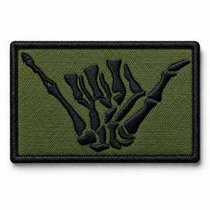 May include: A rectangular embroidered patch featuring an olive green background with a black stitched skeleton hand making a shaka gesture. The patch has a thick black border and a textured fabric surface, showcasing detailed embroidery work.