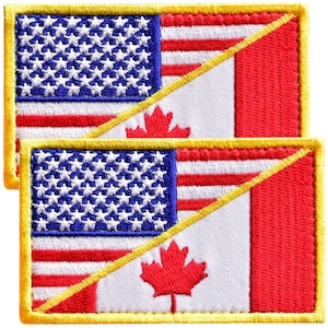May include: Two rectangular embroidered patches featuring a diagonal split design. The left side displays the American flag with white stars on a blue field and red and white stripes. The right side shows the Canadian flag with a red maple leaf.