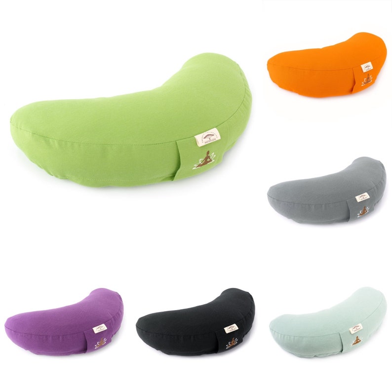 May include: A collection of crescent-shaped yoga pillows in various colors, including green, orange, gray, purple, black, and light green. Each pillow has a small rectangular tag with a logo. The pillows are designed for yoga and meditation.