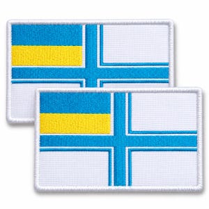 May include: Two rectangular embroidered patches featuring a white background with a bright blue cross design. The upper left quadrant of each patch contains a horizontal yellow stripe set against a blue background, creating a distinct flag-like pattern.