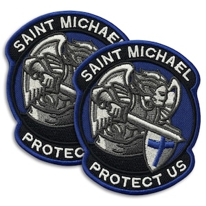 May include: Two embroidered patches featuring a detailed depiction of Saint Michael, with the text "Saint Michael" and "Protect Us" in white lettering on a blue and black background. The patches have a shield and sword.