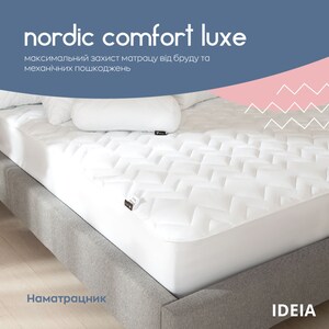 Puede incluir: Un protector de colch&oacute;n blanco con un patr&oacute;n acolchado se muestra en una estructura de cama gris. El texto "nordic comfort luxe" est&aacute; en la parte superior, con texto adicional debajo. Se ve una almohada blanca.