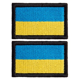 May include: Two embroidered patches featuring the Ukrainian flag. Each patch has a blue top section and a yellow bottom section, with a black border. The patches are rectangular in shape.