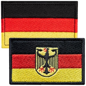 May include: Two rectangular embroidered patches featuring the German flag. One patch displays the black, red, and gold horizontal tricolor. The second patch features the same tricolor design with a central black eagle emblem on a gold shield.