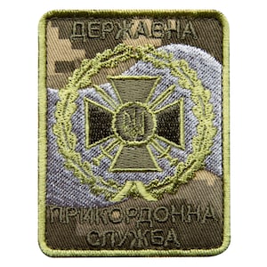 May include: A rectangular patch with a camouflage background and a green border. The patch features a central emblem with a cross design, a wreath, and text in Ukrainian. The colors include shades of green, brown, and gray.