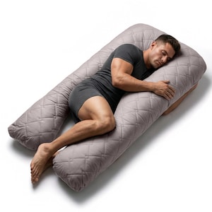May include: A gray U-shaped body pillow with a quilted pattern. The pillow is designed for full body support. The person in the image is lying on the pillow. The pillow is designed to provide comfort and support.