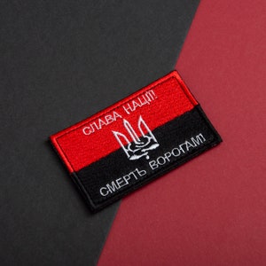 May include: A rectangular patch with a red and black design. The top red section features white text reading "СЛАВА НАЦІЇ" and a white trident symbol. The bottom black section has white text reading "СМЕРТЬ ВОРОГАМ!"