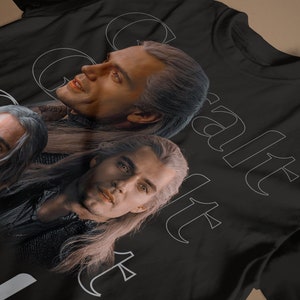 May include: Black t-shirt with a white graphic of three men with long hair. The text "Geralt" and "Yennefer" are printed on the shirt.