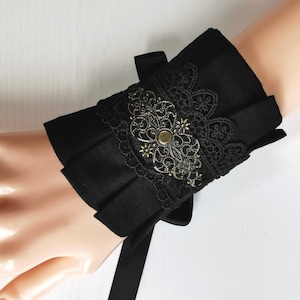 Elegant cuffs in Gothic, Romantic, Victorian, Steampunk style, in black cotton fabric, with lace and bronze metal ornaments