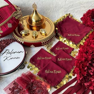 May include: A traditional Turkish henna night ceremony set with a red velvet tray, a gold-trimmed basket, a decorative drum, and red silk scarves with gold coins and the text "Aslının Kınası".