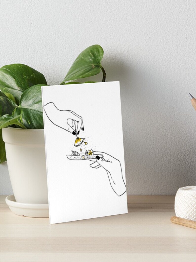 May include: A black and white line drawing of two hands rolling a joint with yellow flowers. The flowers are falling from one hand into the joint.