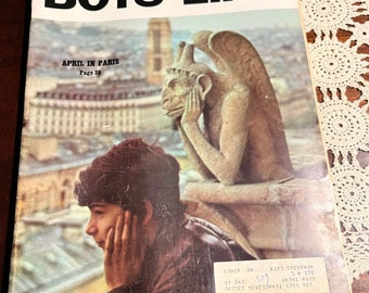 Puede incluir: Una portada de revista vintage de Boys' Life con una foto de un joven mirando la ciudad de París. La portada de la revista tiene el texto "Boys' Life" en letras negras grandes y el texto "April in Paris" en letras negras más pequeñas. La portada de la revista también tiene el texto "Page 28" en letras negras más pequeñas.