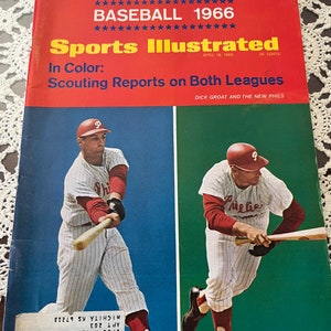 May include: A vintage Sports Illustrated magazine cover from April 18, 1966, featuring the headline "Baseball 1966" and the subheading "Scouting Reports on Both Leagues". The cover features two baseball players in action, one in a red and white uniform with the word "Phi" on the front, and the other in a red and white uniform with the word "Phillies" on the front.