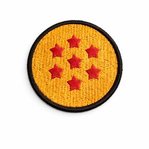 May include: A circular patch with a yellow textured background and six red stars. It has a black border. The design is inspired by a well-known Japanese anime series.