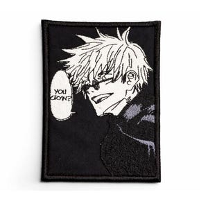 May include: Black embroidered patch featuring a manga-style illustration of a character with spiky white hair and sunglasses. The character is smiling, with a speech bubble that reads "YOU CRYIN?"