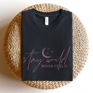 May include: Black t-shirt with a pink graphic that says "stay wild moon child" with a crescent moon and stars.